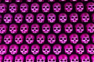 Mehrere Reihen dekorativer Totenköpfe in kräftigem Magenta-Licht, gleichmäßig an einer dunklen Wand montiert – als auffälliges Designelement im Restaurant Holy Taco.